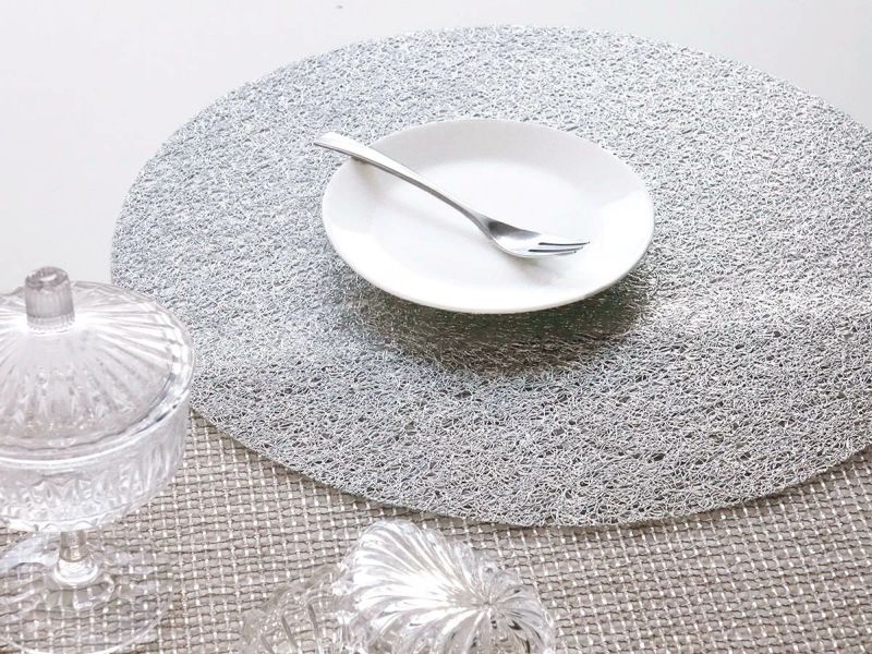 白のテーブルに合わせたチルウィッチの長方形のランチョンマットの中で最もラグジュアリーなレースの繊細さと金属光沢を兼ね備えたシルバーのデザイン  白の20cmプレート皿を際立たせる銀色のランチョンマット