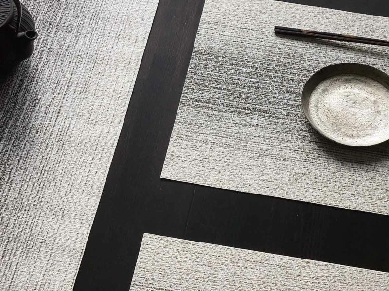 黒色のテーブルに合わせたアイボリーとチャコールグレイの絣のグラデーションのランチョンマットとテーブルランナー