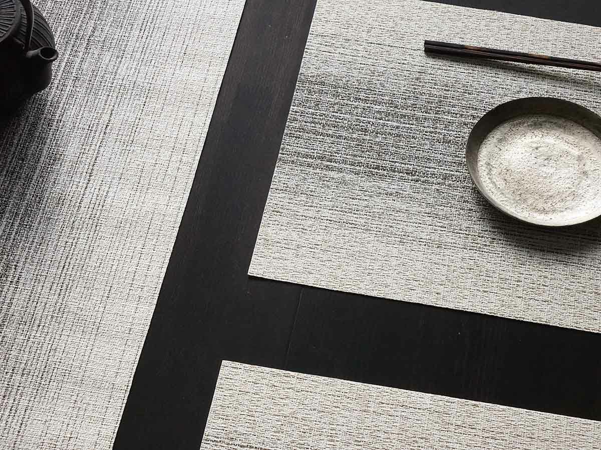 黒色のテーブルに合わせたアイボリーとチャコールグレイの絣のグラデーションのランチョンマットとテーブルランナー