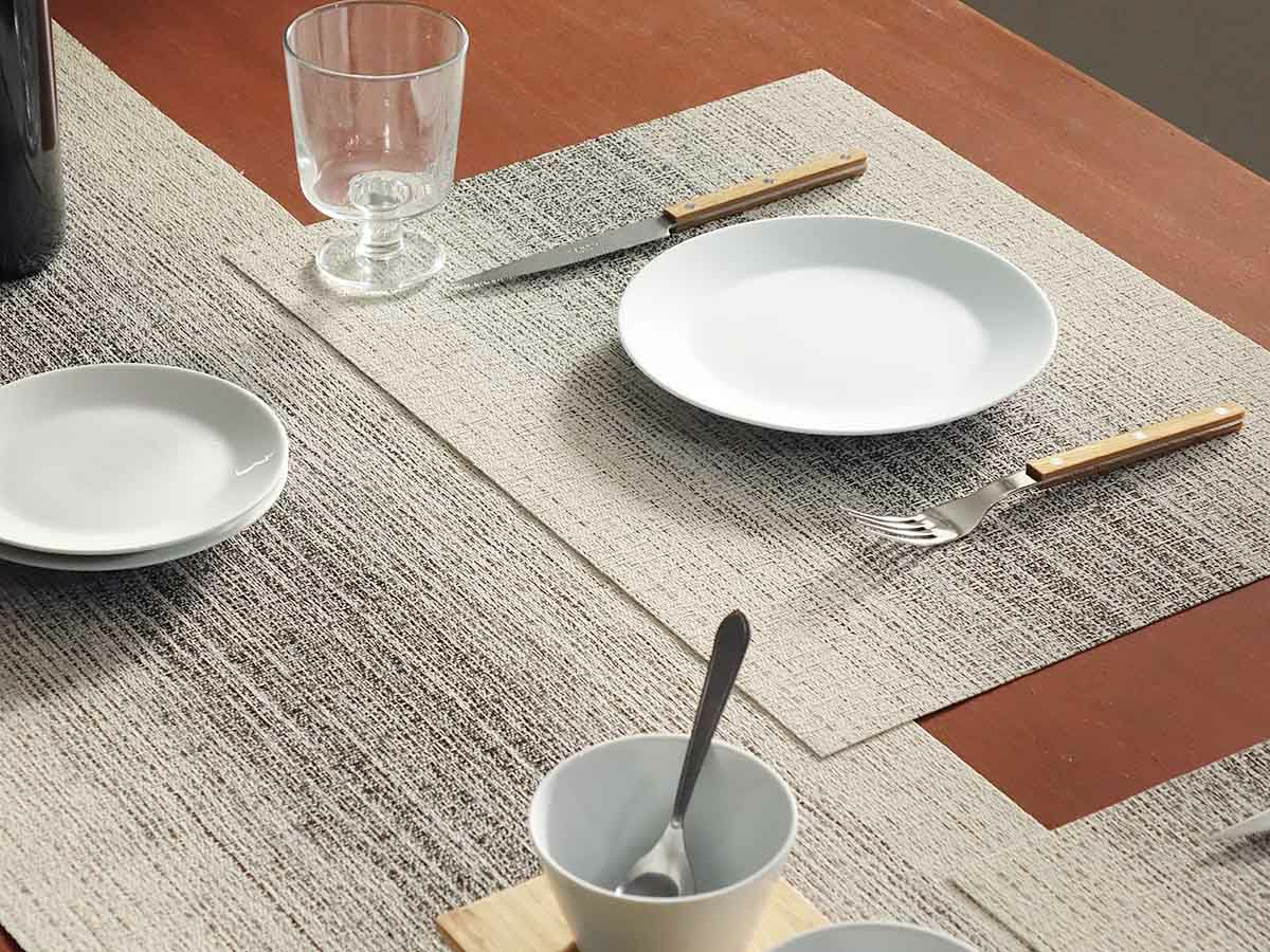 茶色のテーブルに合わせたアイボリーとチャコールグレイの絣のグラデーションのランチョンマットとテーブルランナー