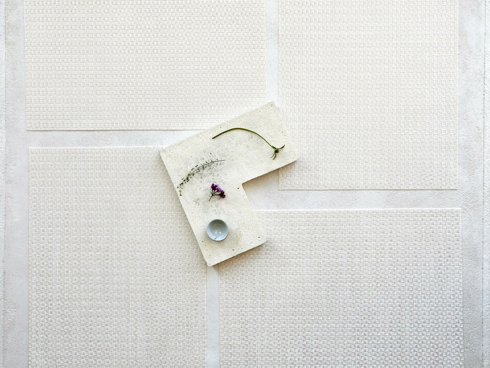 白のテーブルに映える真珠のような光沢のある白色で多面体のテクスチャーの長方形のランチョンマット