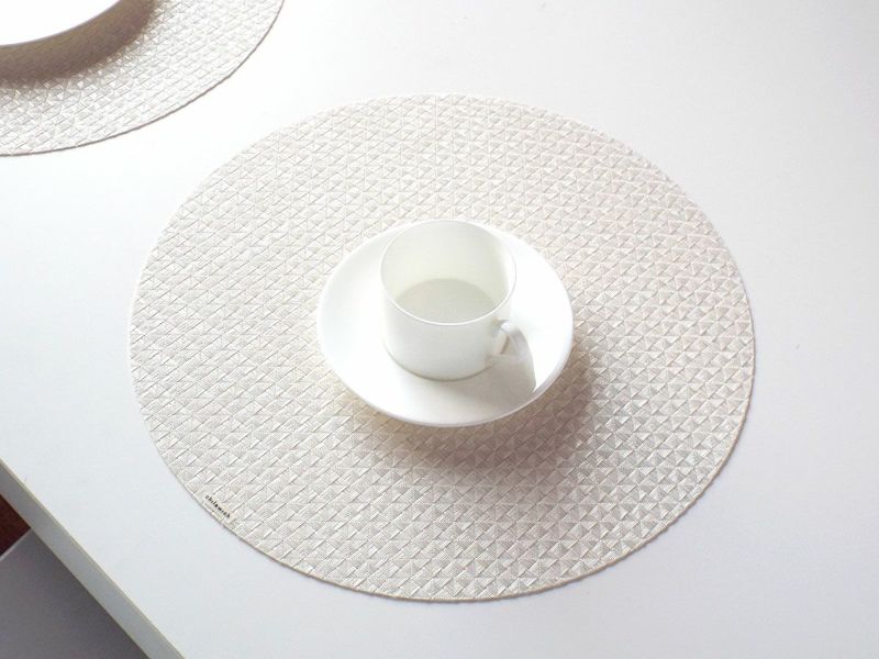 真珠のような光沢のある白色で多面体のテクスチャーの円形ランチョンマット