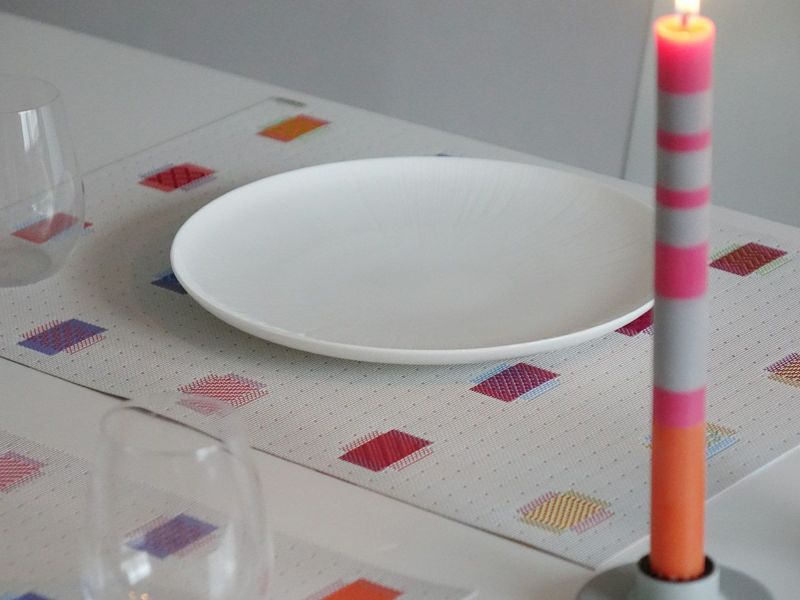 白のテーブルに合わせたマルチカラーの刺繍模様のチルウィッチランチョンマット
