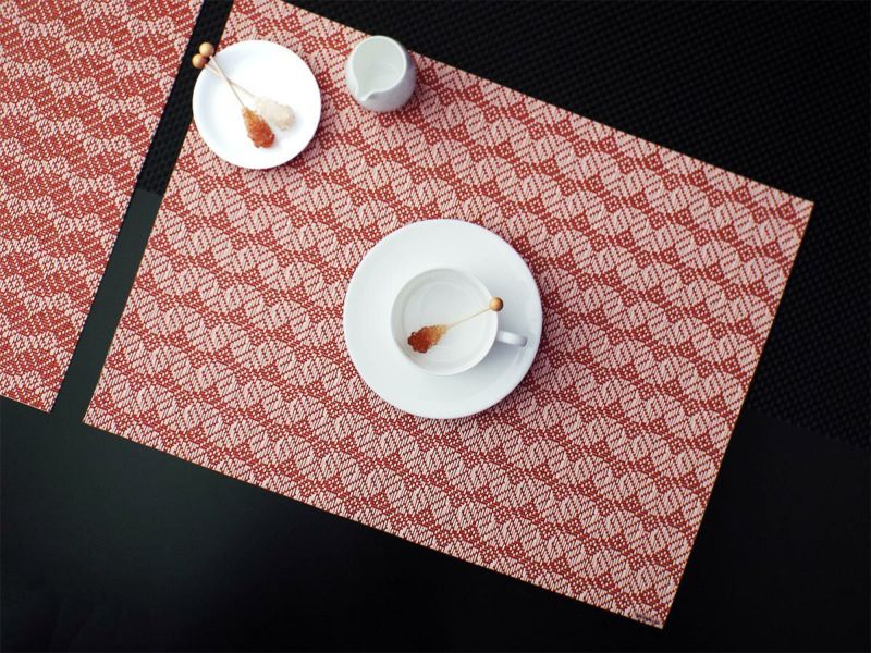 濃淡の朱色の扇模様が連続したランチョンマットと白のカップ＆ソーサー